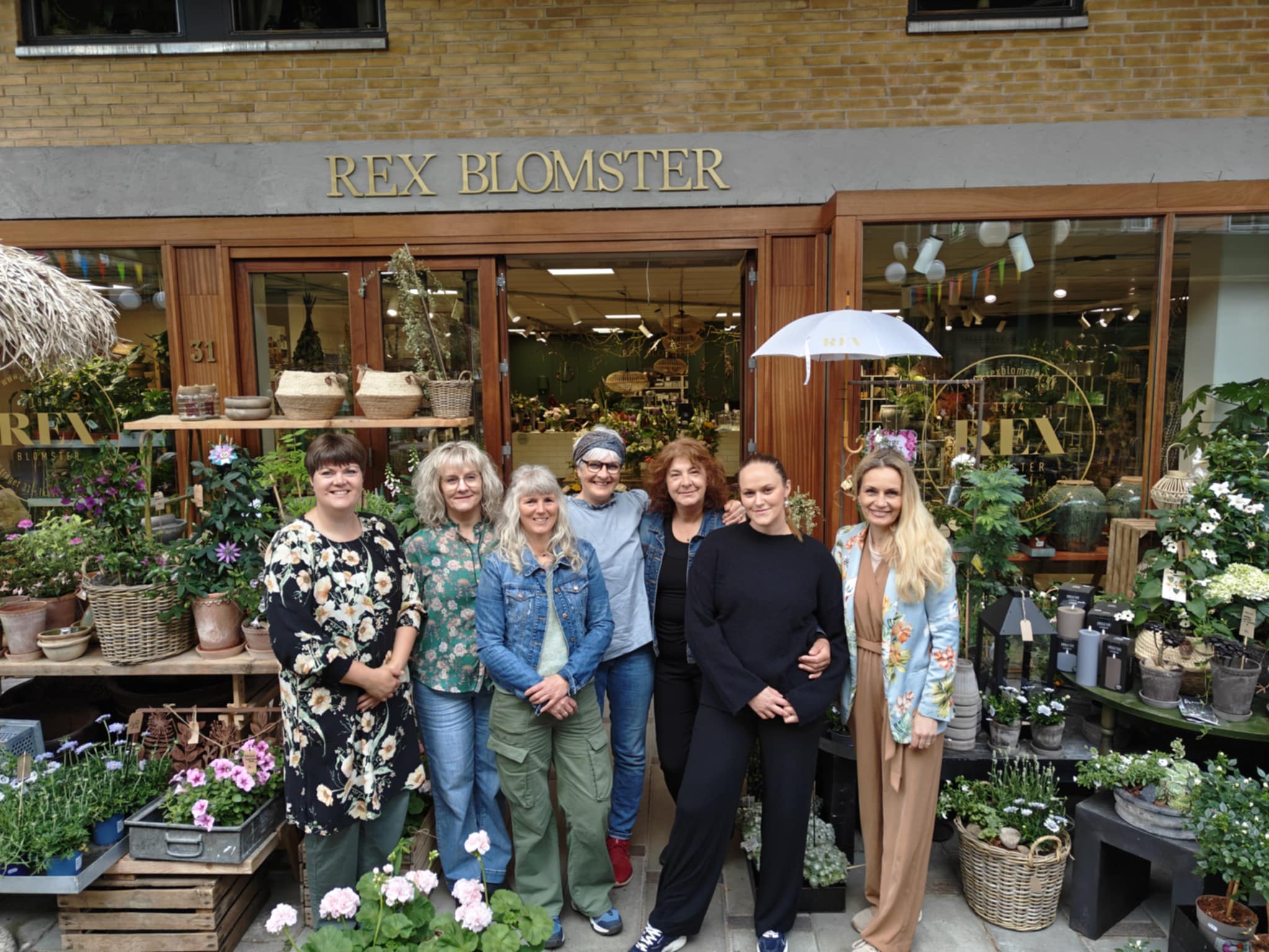 Hænder der holder mobiltelefon og tager billede af blomster